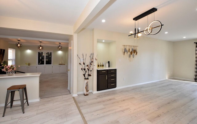 bar featuring decorative light fixtures, recessed lighting, light wood-style floors, and baseboards