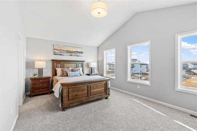 bedroom featuring vaulted ceiling, light colored carpet, and baseboards