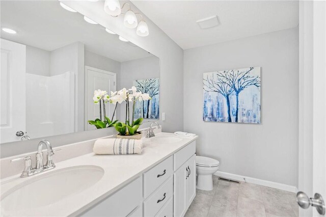 full bath with a sink, visible vents, baseboards, and double vanity