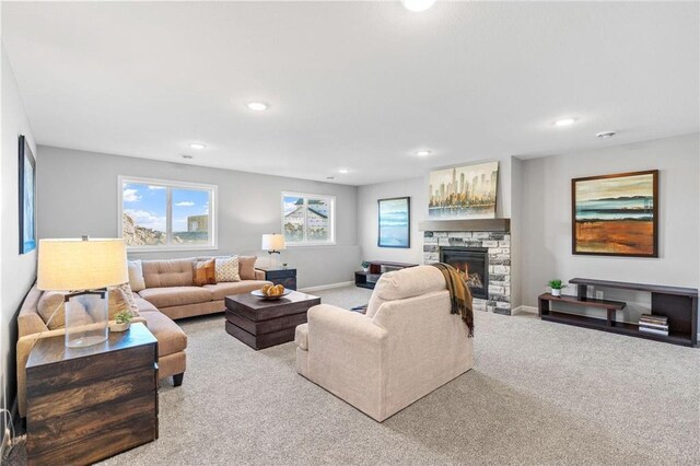 living area with recessed lighting, baseboards, carpet floors, and a stone fireplace