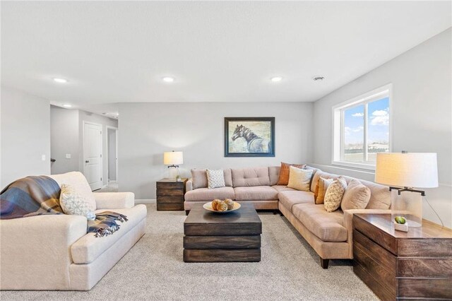 carpeted living area with recessed lighting and baseboards