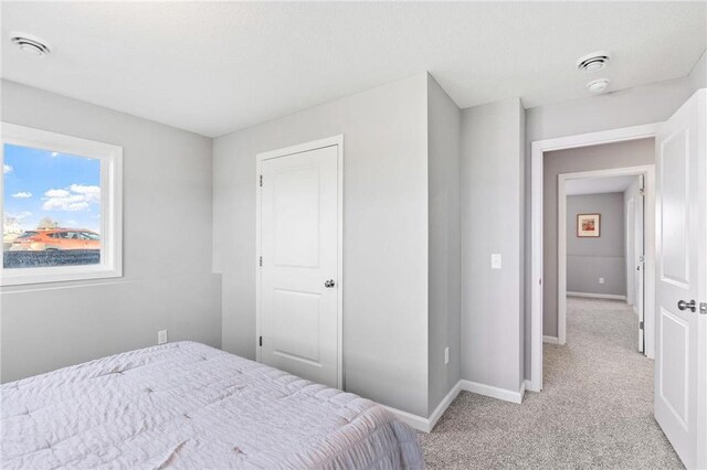 bedroom featuring baseboards and light colored carpet