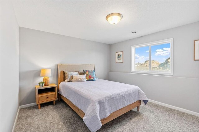 bedroom with light colored carpet and baseboards