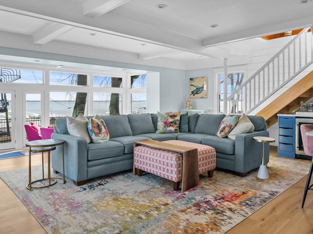 living area featuring stairs, beam ceiling, recessed lighting, and wood finished floors