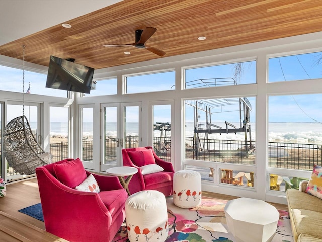 sunroom with a ceiling fan and wood ceiling