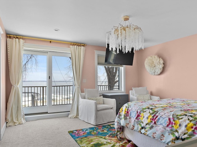 carpeted bedroom with an inviting chandelier, access to exterior, and multiple windows