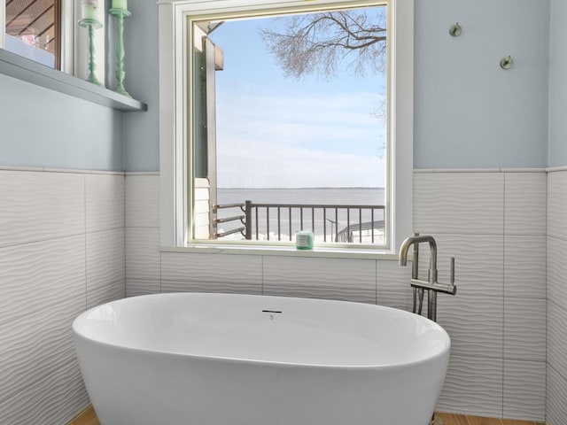 full bath featuring tile walls and a freestanding bath