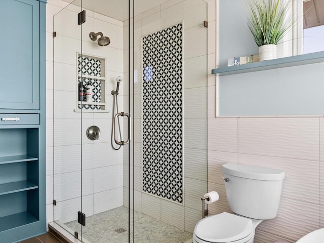 bathroom featuring built in features, a stall shower, toilet, and tile walls