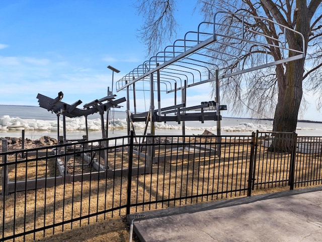 view of community with fence and a water view