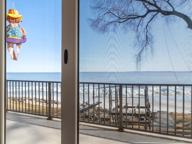 balcony featuring a water view and a beach view