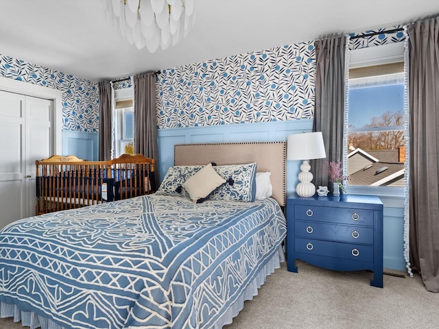 carpeted bedroom with a wainscoted wall and wallpapered walls