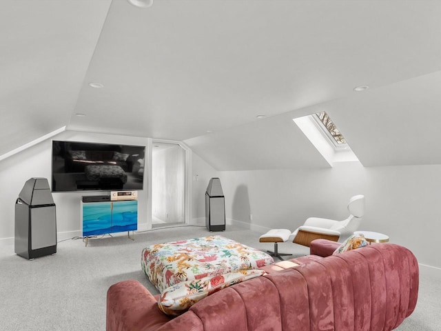 carpeted living area featuring baseboards and lofted ceiling with skylight