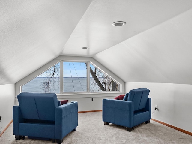 living area featuring vaulted ceiling, carpet, and baseboards