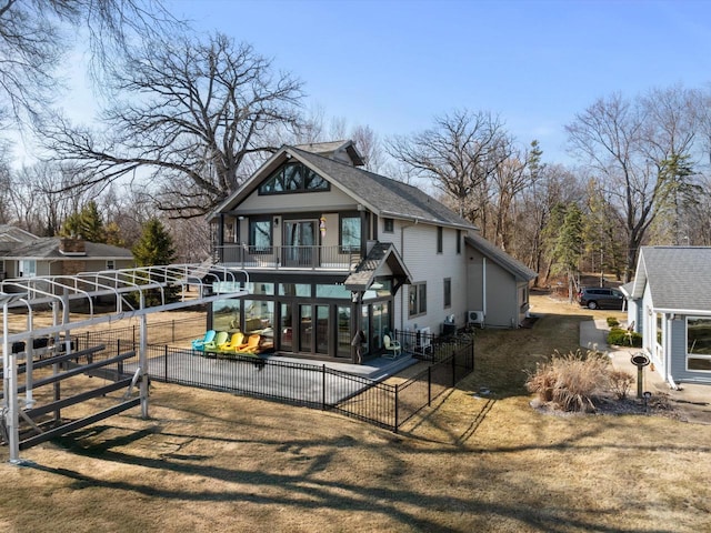 view of front of property featuring a patio area, a balcony, and fence