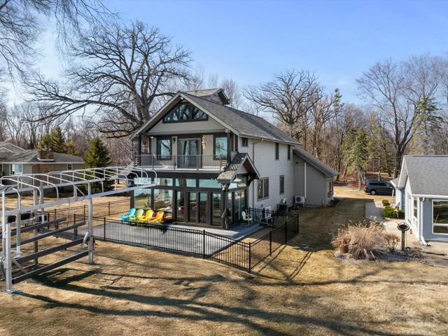 view of front of property featuring a patio area, a balcony, and fence