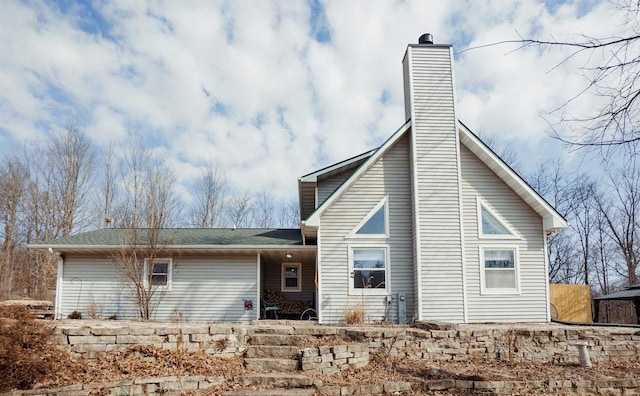 back of house featuring a chimney