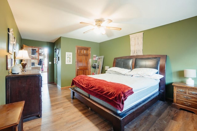 bedroom with wood finished floors, baseboards, and ceiling fan