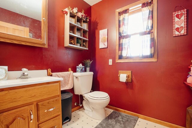 bathroom featuring tile patterned floors, baseboards, toilet, and vanity