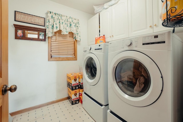 clothes washing area with washing machine and dryer, cabinet space, baseboards, and light floors