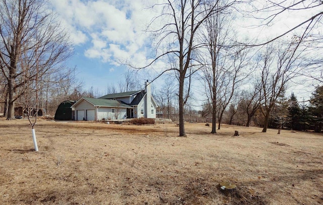 view of property exterior with an attached garage and a chimney