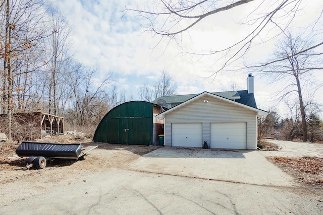 exterior space with driveway and a chimney