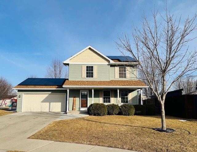 view of front of house featuring a front lawn, concrete driveway, roof mounted solar panels, covered porch, and a garage