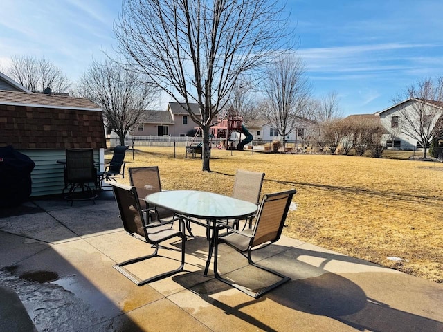 view of patio / terrace with a playground, outdoor dining area, and fence