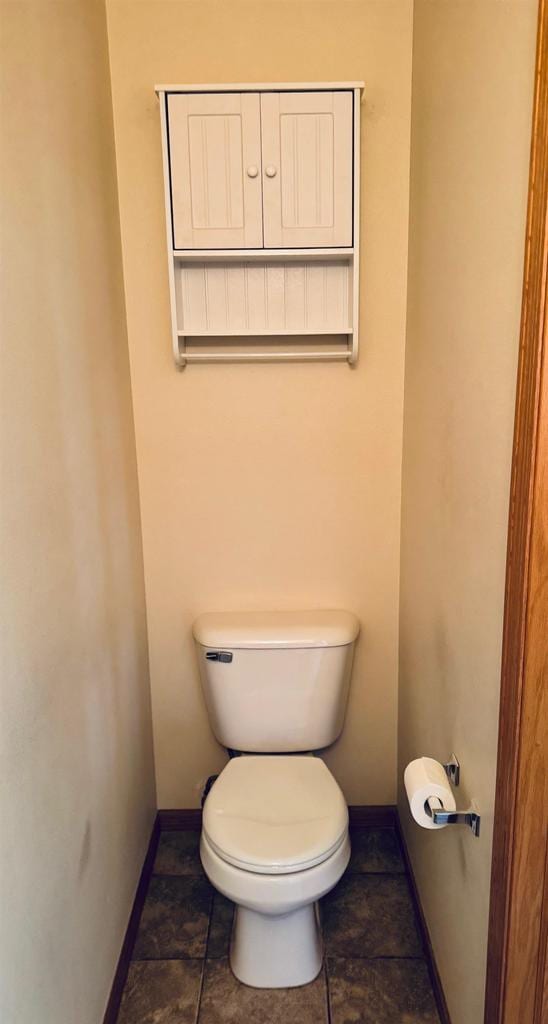 bathroom with toilet and baseboards