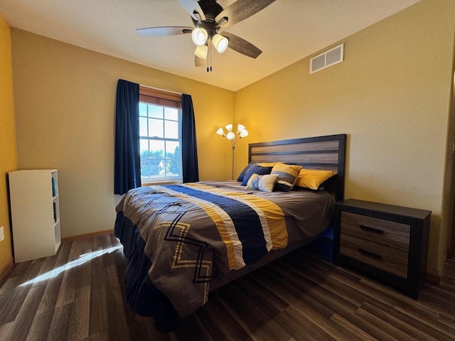 bedroom featuring ceiling fan, visible vents, baseboards, and wood finished floors