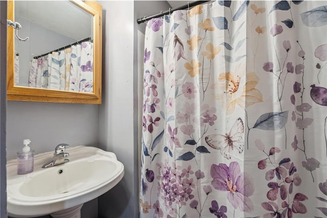 full bathroom with a shower with shower curtain and a sink