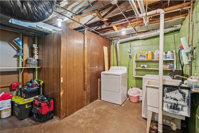 unfinished below grade area with concrete block wall and separate washer and dryer