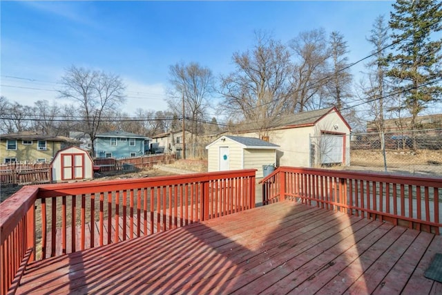 wooden terrace with a storage shed, an outbuilding, fence, and a residential view