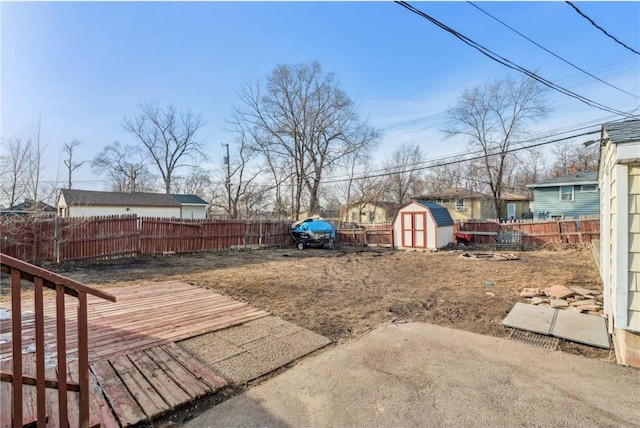 view of yard with a storage unit, an outbuilding, and a fenced backyard