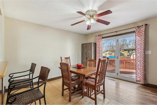 dining area featuring light wood-style flooring, a ceiling fan, and baseboards