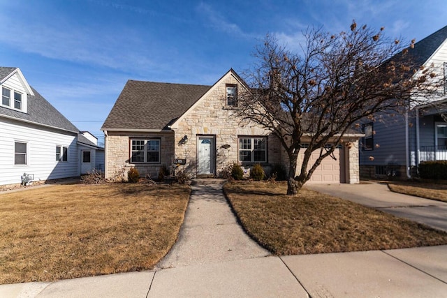 view of front of property with a shingled roof, a front lawn, concrete driveway, a garage, and stone siding