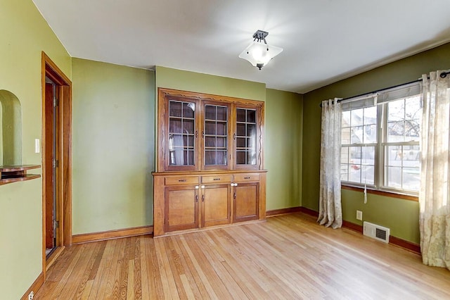 unfurnished dining area featuring visible vents, baseboards, and light wood finished floors