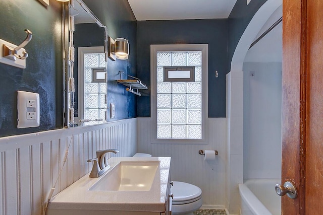 full bath featuring vanity, toilet, and a wainscoted wall