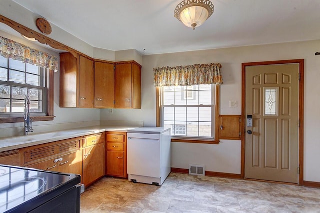 kitchen featuring a sink, visible vents, plenty of natural light, and fridge