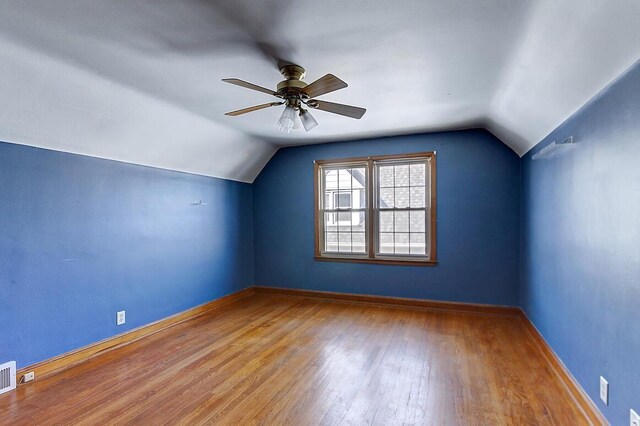 bonus room featuring vaulted ceiling, baseboards, a ceiling fan, and wood finished floors