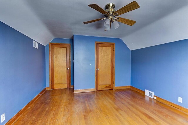 additional living space featuring visible vents, lofted ceiling, baseboards, and wood finished floors