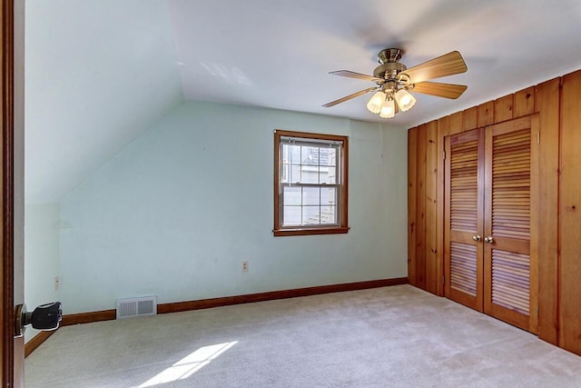 additional living space with lofted ceiling, baseboards, visible vents, and carpet floors