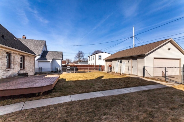 view of yard with a garage, a gate, fence, an outdoor structure, and a wooden deck