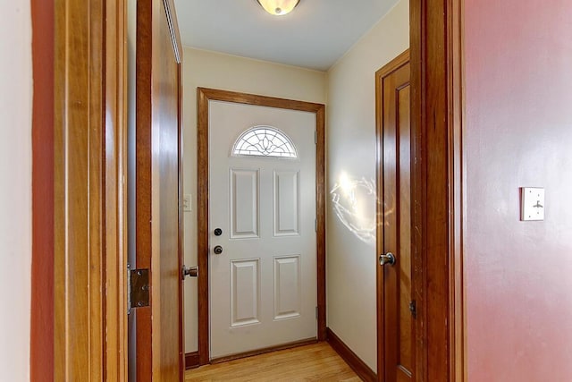 doorway with baseboards and light wood-style floors