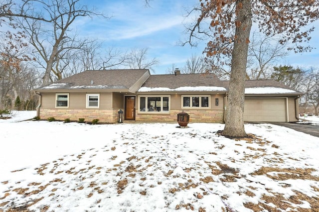 ranch-style home with stone siding, an attached garage, a chimney, and driveway