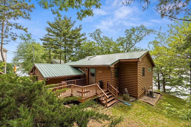 view of front of property featuring central AC, metal roof, and log veneer siding