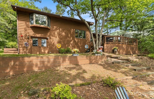 view of front of house with log veneer siding and a deck