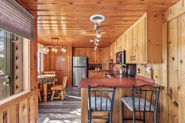 kitchen with visible vents, wood ceiling, appliances with stainless steel finishes, a peninsula, and dark wood-style floors