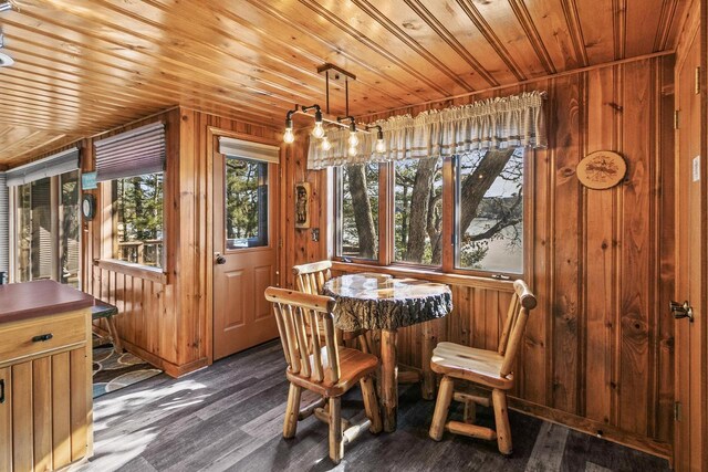 dining room with wooden walls, wood ceiling, and dark wood-style flooring