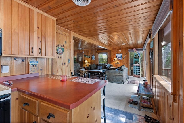 kitchen with carpet, visible vents, wood ceiling, wood walls, and open floor plan