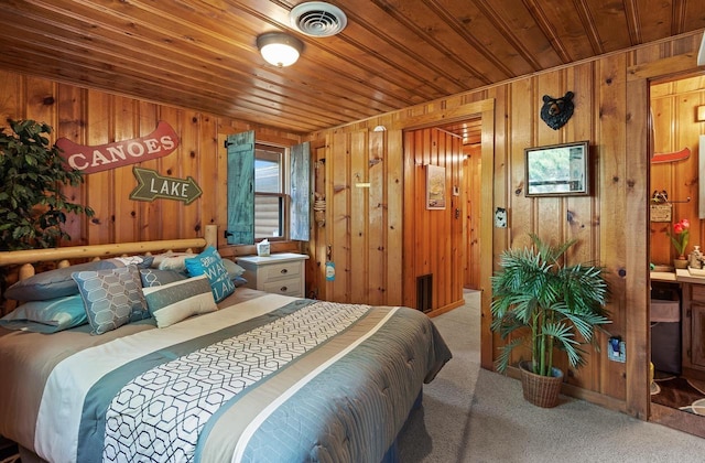 carpeted bedroom with wood ceiling, visible vents, and wood walls